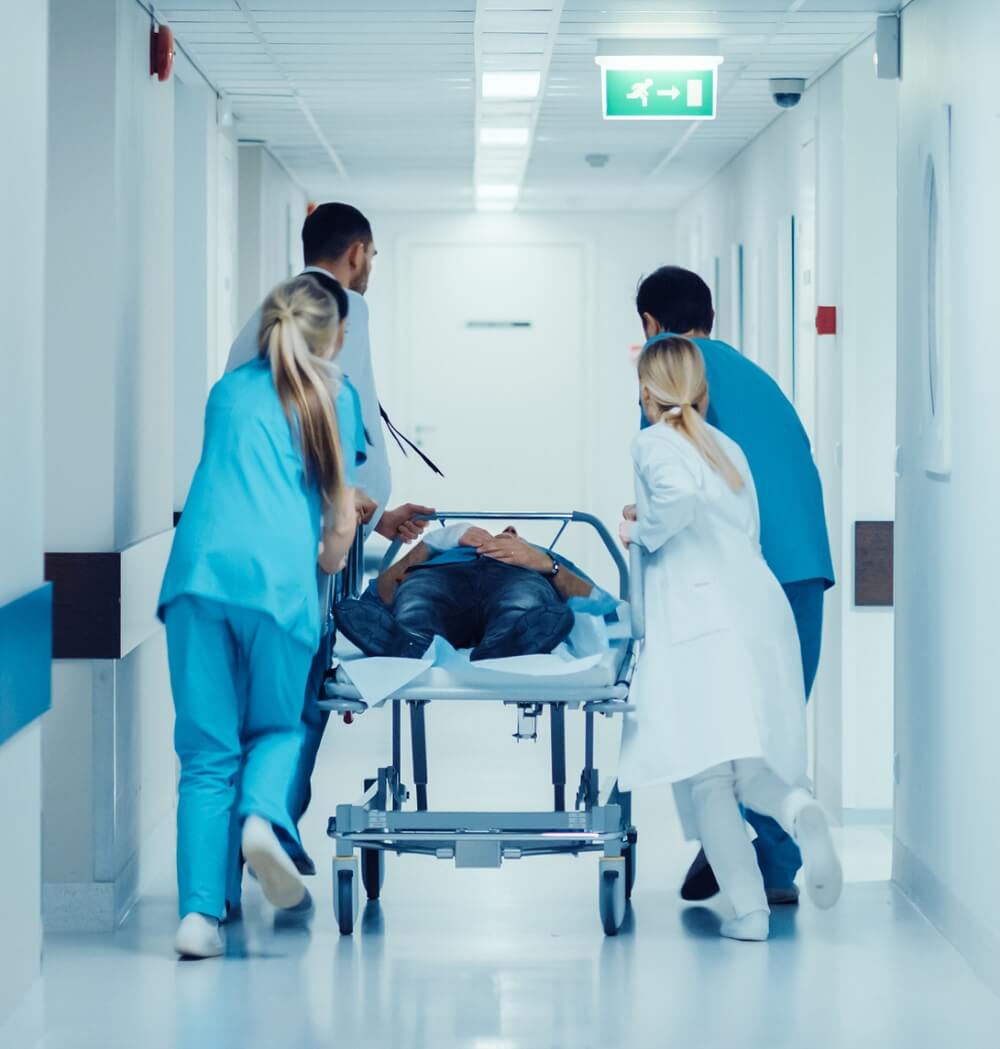 Acute Care Nurse Practitioners and Doctors Escorting a Patient on Gurnee