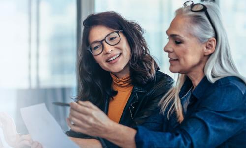 Women business analysts reviewing data in reports