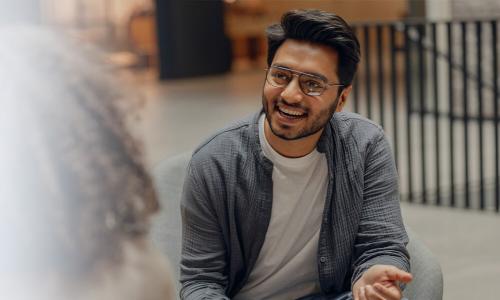 MBA graduate in Kansas at first job smiling with team member during meeting 