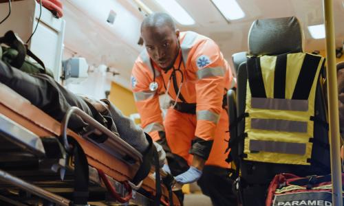 EMT Emergency Medical Technician Loading Patient Into Ambulance 