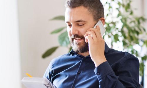 IT Manager Discussing Team Strategy On Phone In Office 