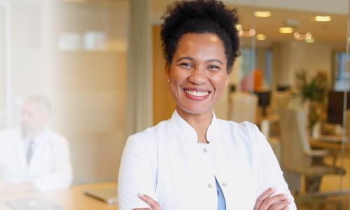 DNP nurse executive smiling in conference room during team meeting