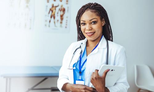 Women's health nurse practitioner with a DNP smiling with clipboard in clinic