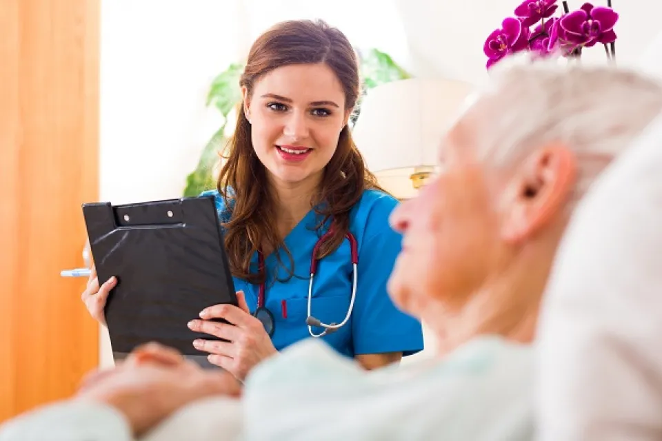 Smiling Medical Assistant with Clipboard Speaking with Geriatric Patient