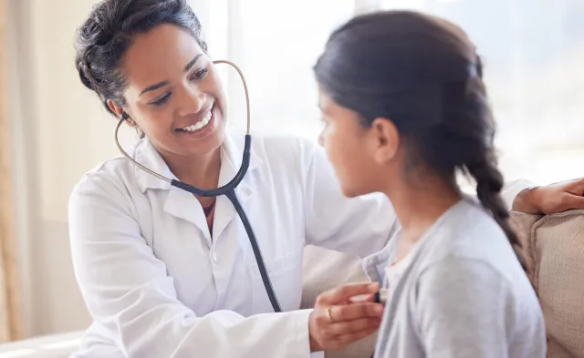 Primary Care Pediatric Nurse Practitioner Taking Heart Rate of Child Patient