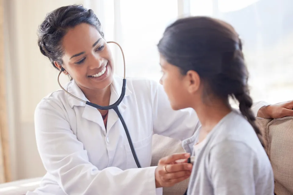 Primary Care Pediatric Nurse Practitioner Taking Heart Rate of Child Patient