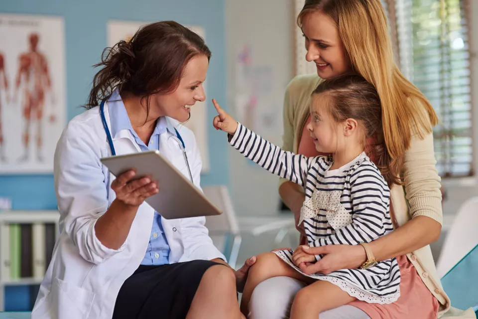 Pediatric Nurse Practitioner Smiling with Young Patient During Exam